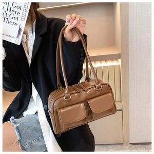 Close-up of brown vintage leather handbag with dual front pockets and zipper closure