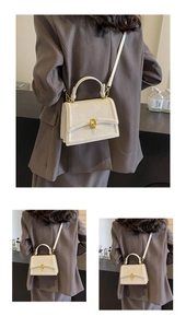 Détail d'un sac bandoulière blanc crème avec fermoir chaîne dorée et fine bandoulière