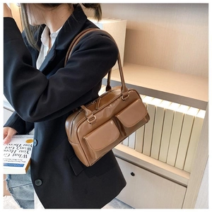 Detail view of brown vintage leather shoulder bag with double front flap pockets