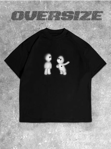 Detalle de camiseta negra oversize con estampado de personajes artísticos y texto gráfico