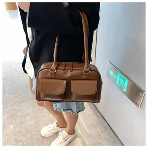 Retro brown leather shoulder bag with dual front pockets and long strap detail