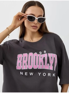 Close-up of pink Brooklyn New York 98 graphic print on dark gray cotton t-shirt