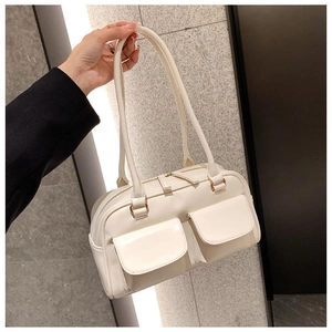 Macro view of cream PU leather handbag detailing front pockets and gold hardware