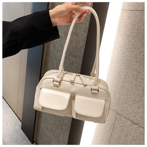 Detail view of cream white PU leather handbag featuring two symmetric front flap pockets