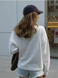 Detail view of white loose cotton long sleeve t-shirt with dropped shoulder design