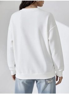 Detail view of white crewneck sweatshirt with ribbed hem and dropped shoulder back design