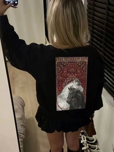 Detail of artistic rug print with horses on a black cotton oversized long sleeve t-shirt