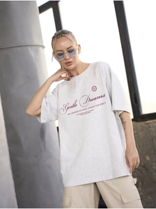 Detail of light gray cotton oversized t-shirt featuring artistic Gentle Dreams typography