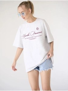 Close-up of light grey cotton oversize t-shirt featuring Gentle Dreams printed text