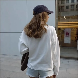 Women's white cotton loose fit long sleeve T-shirt with casual denim shorts and handbag