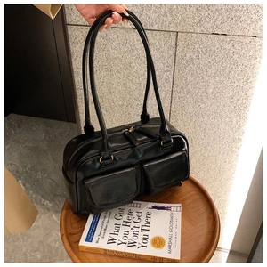 Detail of black glossy handbag with double front pockets and Y2K vintage aesthetic