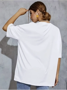 Vue arrière d'un t-shirt oversize en coton blanc montrant le drapé et la texture douce