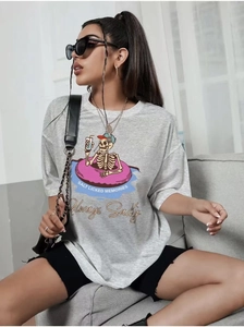 Détail d'un t-shirt gris en coton avec illustration de crâne colorée et texte graphique