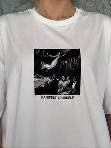 Close-up of MANIFEST YOURSELF graphic print on white cotton crewneck t-shirt