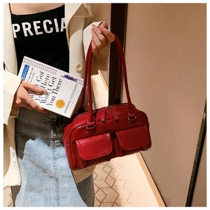 Detail of red leather handbag featuring dual front pockets and glossy retro finish
