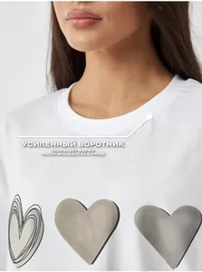 Close-up of the reinforced neckline on a white cotton T-shirt with heart print
