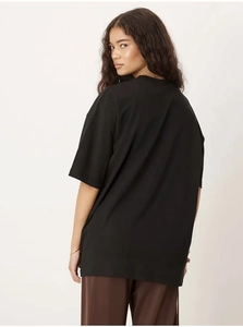 Détail d'un t-shirt noir oversize en coton avec épaules tombantes et coupe décontractée