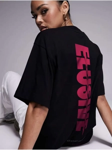 Close-up of pink 'ELUSIVE' graphic print on the back of a black oversized cotton t-shirt