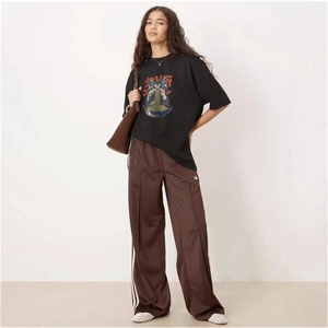 T-shirt noir oversize en coton avec imprimé chat et pantalon de jogging marron à rayures