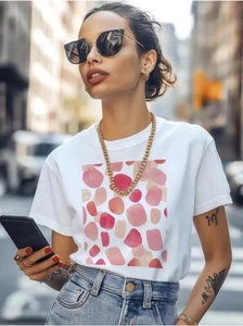 Detail of white cotton crew neck T-shirt featuring pink abstract polka dot print on street