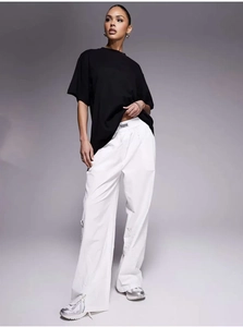 Detail of waist label on white wide-leg trousers paired with black cotton T-shirt