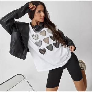 Women's white cotton T-shirt with heart prints, styled with leather jacket and shorts