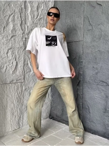 Close-up of white cotton T-shirt with black portrait print and MANIFEST YOURSELF text
