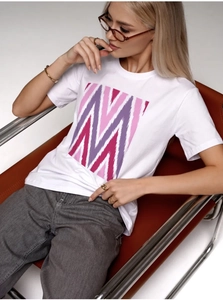 Détail d'un t-shirt blanc en coton avec imprimé géométrique rose vif sur la poitrine