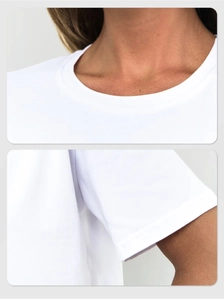 Detail of round neckline and double-stitched sleeves on white polka dot cotton t-shirt