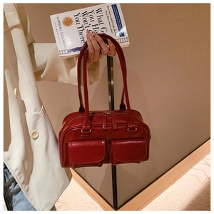 Detail view of burgundy shiny PU leather crossbody bag with dual front flap pockets