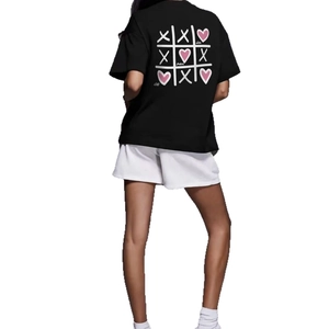 T-shirt noir en coton avec imprimé grille de cœurs roses au dos et short blanc