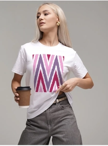 Détail d'un t-shirt blanc en coton avec imprimé géométrique rose et violet sur la poitrine