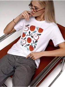 Dettaglio della stampa artistica mela rossa su t-shirt bianca in cotone per look casual