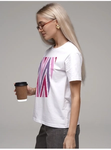 Détail d'un t-shirt en coton blanc avec imprimé géométrique rose et jean gris foncé