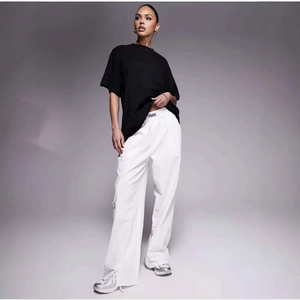 Classic loose black cotton T-shirt paired with white wide-leg joggers and silver sneakers