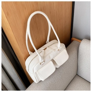 White minimalist square tote bag with front pockets on light wood and grey fabric