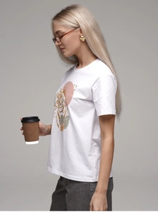 Détail de l'imprimé artistique tigre et fleurs tropicales sur t-shirt coton blanc