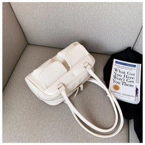 Detail of a creamy white PU leather handbag featuring two symmetric front flap pockets