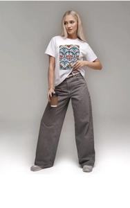 Close-up of women's white cotton tee with ethnic geometric print and high waist jeans