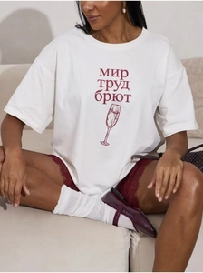 Detail eines weißen Baumwoll-T-Shirts mit rotem Grafikprint und burgunderfarbenen Shorts