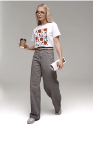 Primo piano di una t-shirt bianca in cotone con stampa di mela e jeans a vita alta