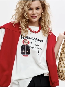 Close-up of Matryoshka doll graphic on white cotton oversize t-shirt with red necklace