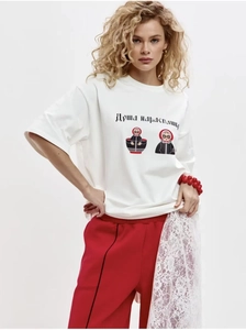Détail du t-shirt blanc en coton avec motif poupée russe et pantalon rouge en dentelle