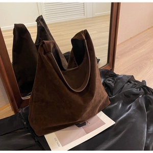 Detail of deep brown frosted leather hobo bag on black silk showing rich matte texture