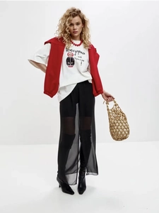 Close-up of white cotton oversize T-shirt with red Matryoshka print and layered styling