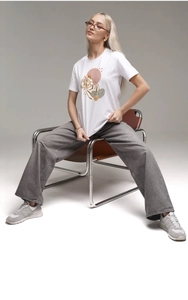Détail d'un t-shirt en coton blanc avec motif graphique de tigre et feuilles tropicales