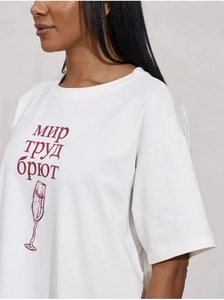 Detail eines weißen Baumwoll-T-Shirts mit rotem russischem Text und Sektglas-Aufdruck