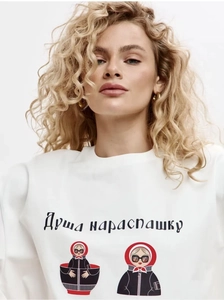 Détail du sweat-shirt blanc en coton avec texte russe et imprimé Matriochka moderne