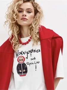 Close-up of white cotton T-shirt with graphic print and red layered accessories