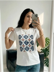 Close-up of white cotton t-shirt featuring blue floral geometric prints on a female model